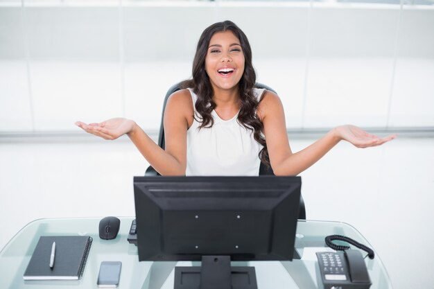 riendo-linda-empresaria-sentado-detras-escritorio_13339-242097